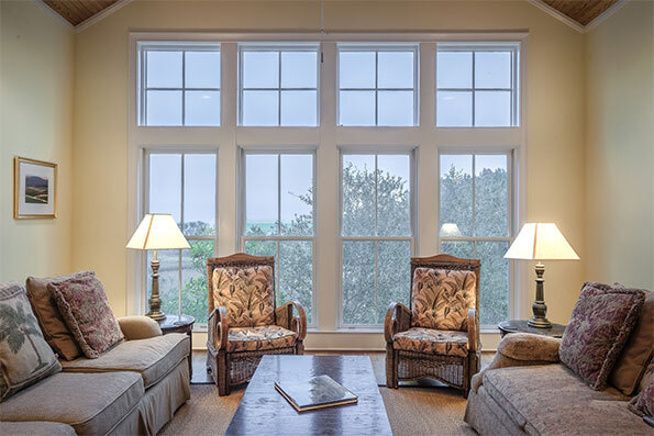 Sitting room with two sofas, two chairs, coffee table and windows in elderly home covered by commercial property insurance.